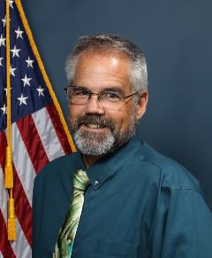 Brian Bruchey Brian Bruchey in front of flag
